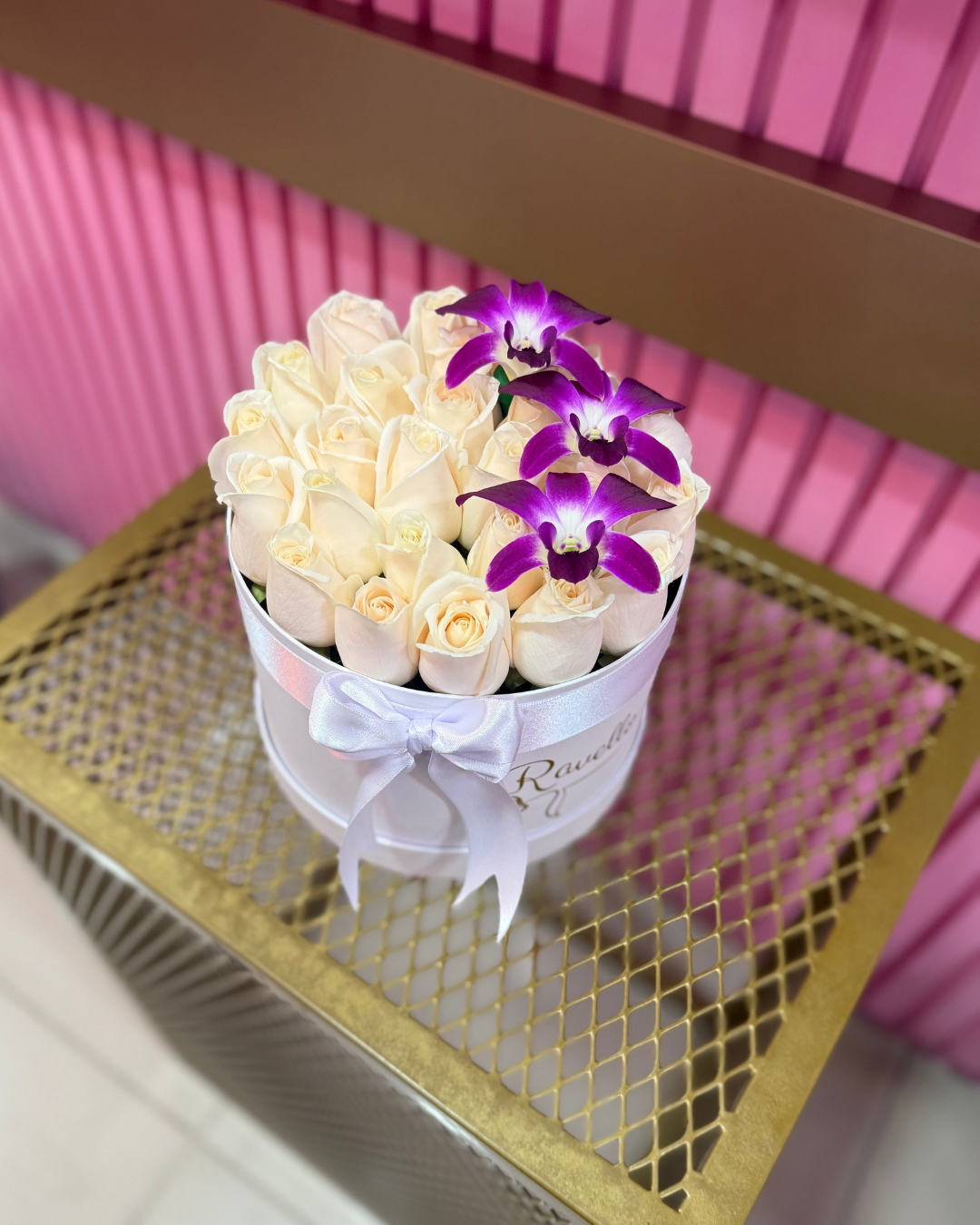 Caja redonda con rosas blancas y orquídeas